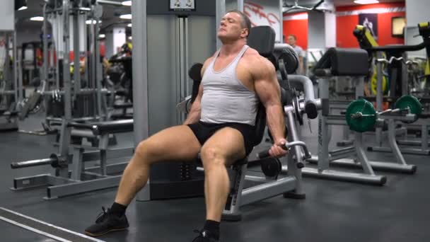 RÚSSIA, TOGLIATTI - SETEMBRO 20, 2018: Homem atlético treina no ginásio. Treinamento de bíceps — Vídeo de Stock