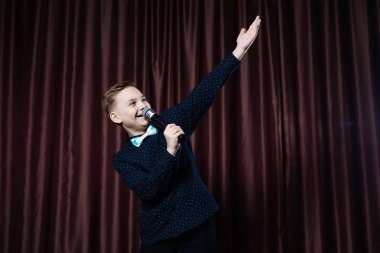 küçük çocuk mikrofon şarkı. karaoke çocuk. moda saç kesimi