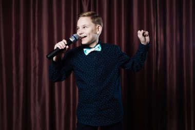 küçük çocuk mikrofon şarkı. karaoke çocuk. moda saç kesimi