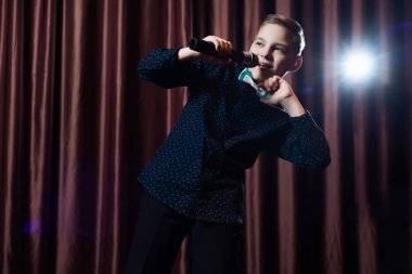 küçük çocuk mikrofon şarkı. karaoke çocuk. moda saç kesimi