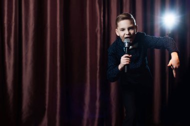 küçük çocuk mikrofon şarkı. karaoke çocuk. moda saç kesimi