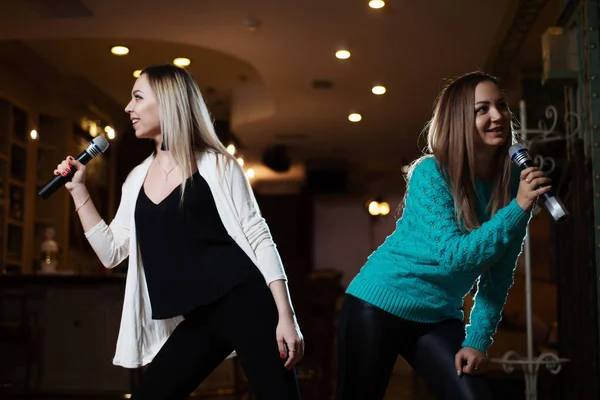 Restoran mikrofonlar Karaoke şarkılar söyleyen güzel genç kadın