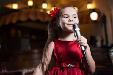 Kız mikrofon ile. Küçük bir çocuk karaoke şarkı kadar yakın