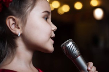 Kız mikrofon ile. Küçük bir çocuk karaoke şarkı kadar yakın