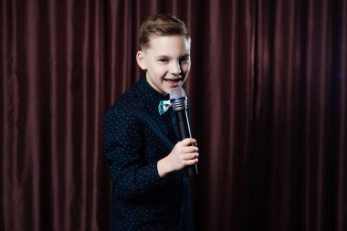 küçük çocuk mikrofon şarkı. karaoke çocuk. moda saç kesimi