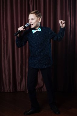 küçük çocuk mikrofon şarkı. karaoke çocuk. moda saç kesimi