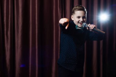 küçük çocuk mikrofon şarkı. karaoke çocuk. moda saç kesimi