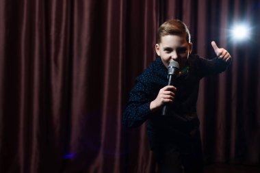 küçük çocuk mikrofon şarkı. karaoke çocuk. moda saç kesimi
