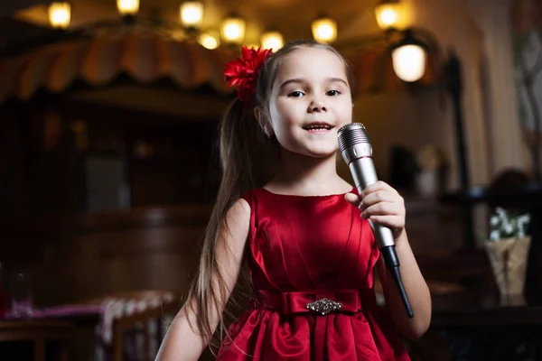 Kız mikrofon ile. Küçük bir çocuk karaoke closeup şarkı söylüyor.