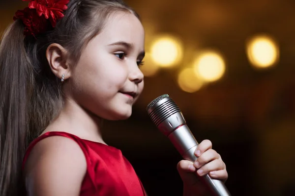 Kız mikrofon ile. Küçük bir çocuk karaoke closeup şarkı söylüyor.