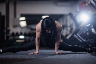 Genç atletik kadının yapması spor salonunda böler. Yoga yaparken kadın