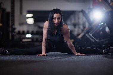 Genç atletik kadının yapması spor salonunda böler. Yoga yaparken kadın