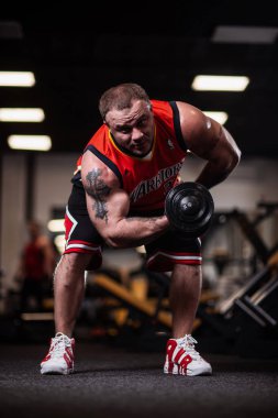 Rusya, Samara - 18 Aralık 2018: Büyük atletik adam trenler jimnastik salonu. Eğitim pazı bir dumbbells ile