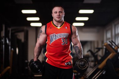 Rusya, Samara - 18 Aralık 2018: Büyük atletik adam trenler jimnastik salonu. Eğitim pazı bir dumbbells ile