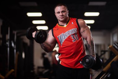 Rusya, Samara - 18 Aralık 2018: Büyük atletik adam trenler jimnastik salonu. Eğitim pazı bir dumbbells ile