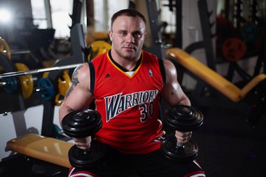 Rusya, Samara - 18 Aralık 2018: Büyük atletik adam trenler jimnastik salonu. Egzersiz sonrası dinlenme