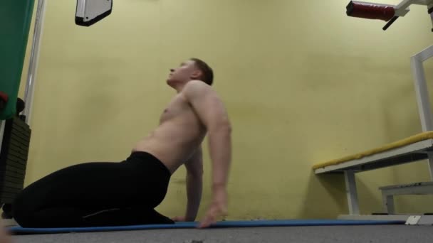 Uomo che si allunga il braccio prima dell'allenamento in palestra. Fitness forte atleta maschio in piedi riscaldamento interno . — Video Stock