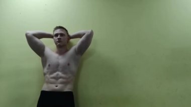 Atletik erkek spor salonunda duvara poz