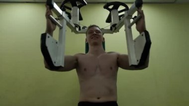 Genç adam göğüs kasları jimnastik salonu, fitness yapıyor trenler