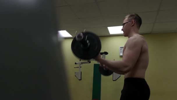 Barbell hombre en el gimnasio entrenamiento bíceps fitness levantamiento de pesas — Vídeos de Stock