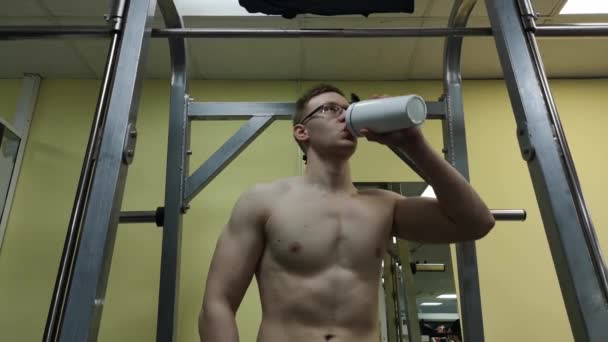 Młody człowiek wody pitnej w siłowni. Facet używa shake białka — Wideo stockowe