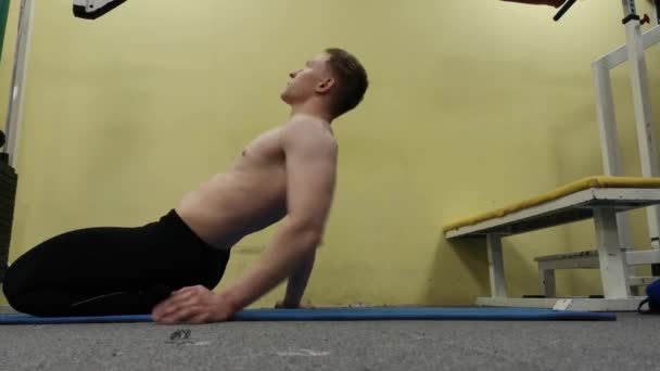 Człowiek rozciąganie ramię przed treningiem siłowni. Fitness silny męski sportowiec stojący wewnątrz ocieplenia. — Wideo stockowe