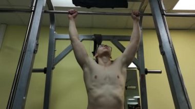 Rusya, Togliatty - 21 Şubat 2019: Genç adam fitness salonunda devreye girer. Atlet çubuğunda çekti