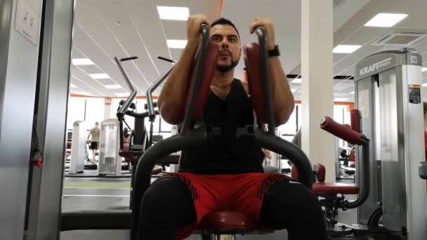 РОССИЯ, ТОГЛИАТТЫ - 23 февраля 2019 года: Атлетик тренирует грудные мышцы в тренажерном зале, занимается фитнесом — стоковое видео