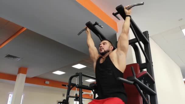 RUSSIA, TOGLIATTY - FEBRUARY 23, 2019: Athletic man trains the muscles of the abdomen, hanging on the bar in the gym — Stock Video