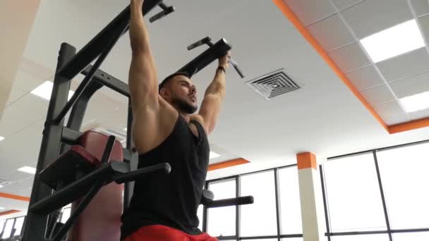 Rusko, Togliatty - 23 února 2019: Atletický muž trénuje svaly břicha, visí na baru v posilovně — Stock video