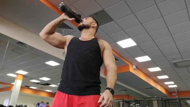Ryssland, Togliatty - 23 februari 2019: Vuxen man dricksvatten i gymmet. Killen använder en proteinshake — Stockvideo