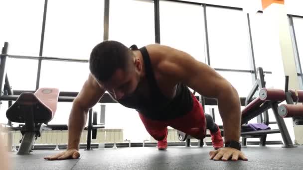 RUSSIE, TOGLIATTÉ - 23 FÉVRIER 2019 : Jeune homme sportif effectue des pompes dans la salle de gym. L'athlète est engagé dans la forme physique — Video