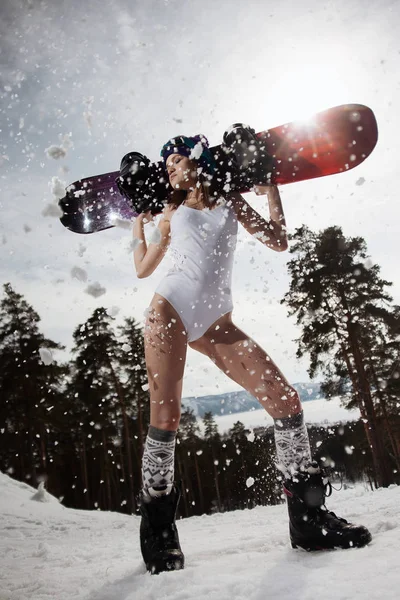 Woman dressed in a swimsuit posing with a snowboard in her hands. Winter sport — Stock Photo, Image