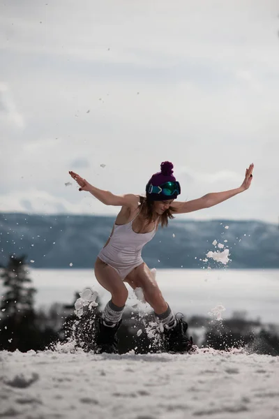 Mulher vestida de fato de banho posando com um snowboard nas mãos. Desporto de Inverno — Fotografia de Stock