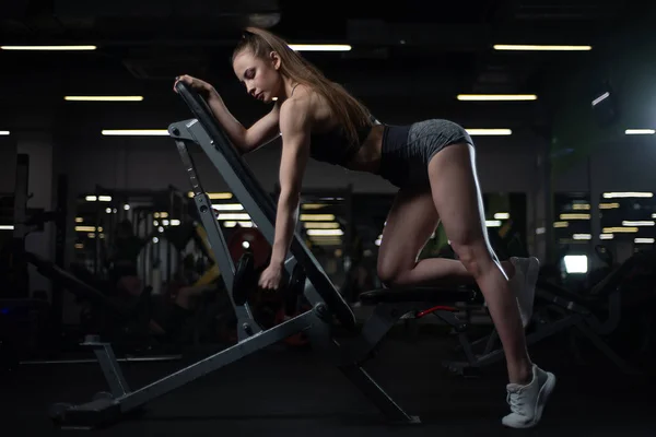 Fitness brunette vrouw met opgeleide lichaamstraining terug met halter op sportschool — Stockfoto
