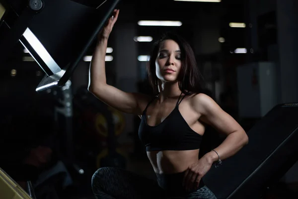 Fitness tjej poserar i gymmet, visar upp sin kropp och avkopplande efter ett träningspass — Stockfoto