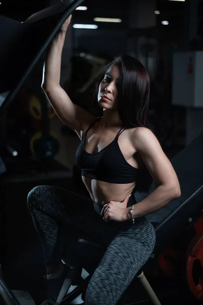 Chica de fitness posando en el gimnasio, mostrando su cuerpo y relajarse después de un entrenamiento — Foto de Stock