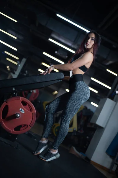 Девушка позирует в спортзале, показывая свое тело и расслабляясь после тренировки — стоковое фото