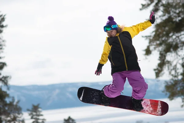 骑滑雪板的妇女跳。冬季运动。在滑雪板上装备的女孩 — 图库照片