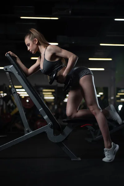 Fitness morena mujer con entrenamiento corporal entrenado espalda con mancuerna en el gimnasio — Foto de Stock