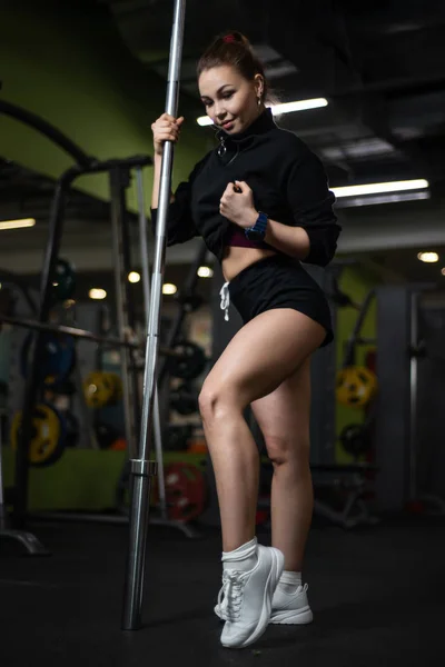 Menina posando no ginásio, mostrando seu corpo, segurando um sino — Fotografia de Stock