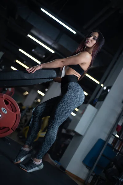 Фітнес дівчина позує в спортзалі, показує її тіло і розслабляється після тренування — стокове фото