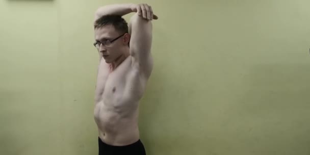 Homem esticando o braço antes do treino de ginástica. Fitness forte atleta masculino em pé interior aquecimento . — Vídeo de Stock