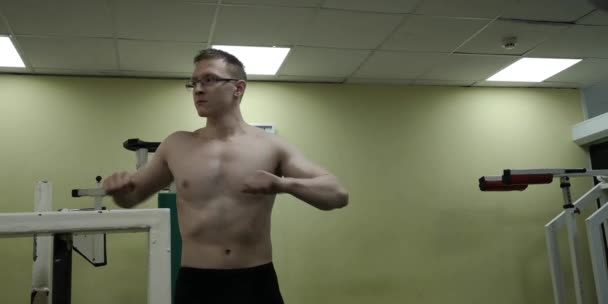 Man stretching arm voor gym workout. Fitness sterke mannelijke atleet staande indoor warming up. — Stockvideo