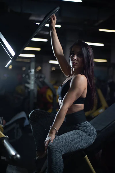 Chica de fitness posando en el gimnasio, mostrando su cuerpo y relajarse después de un entrenamiento —  Fotos de Stock