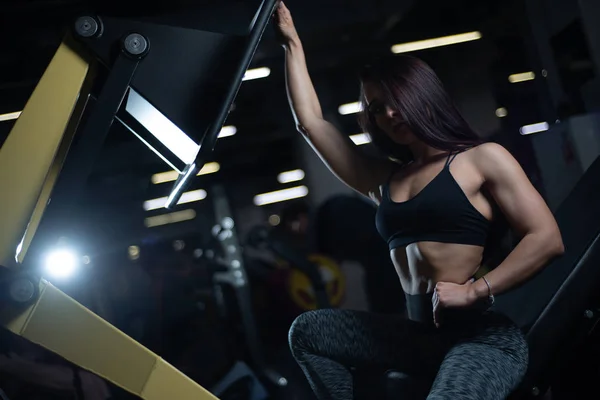 Fitnessmädchen posiert im Fitnessstudio, zeigt ihren Körper und entspannt sich nach einem Training — Stockfoto