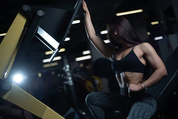 Chica de fitness posando en el gimnasio, mostrando su cuerpo y relajarse después de un entrenamiento — Foto de Stock