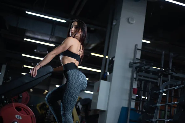 Chica de fitness posando en el gimnasio, mostrando su cuerpo y relajarse después de un entrenamiento —  Fotos de Stock