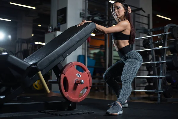 Fitness tjej poserar i gymmet, visar upp sin kropp och avkopplande efter ett träningspass — Stockfoto