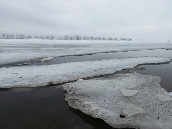 Gelo flutuante partido em uma paisagem nevada vazia no início da primavera — Fotografia de Stock